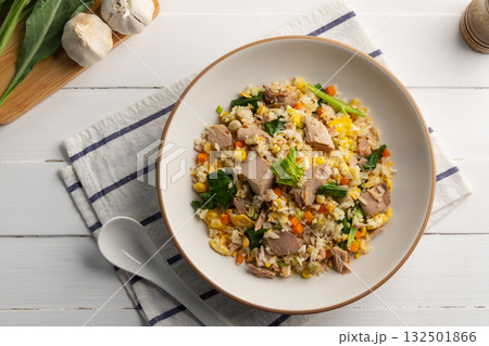 Tuna fried rice,stir fry rice with canned tuna fish ,kale ,corn ,carrot ,green peas and egg in white plate.Top view. Tuna fried rice,stir fry rice with canned tuna fish ,kale ,corn ,carrot ,green peas and egg in white plate.Top view. 132501866
