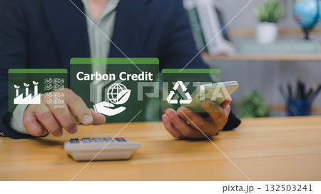 Carbon credit and sustainability concept businessman using smartphone with eco-friendly digital icons and carbon trading system Carbon credit and sustainability concept businessman using smartphone with eco-friendly digital icons and carbon trading system 132503241