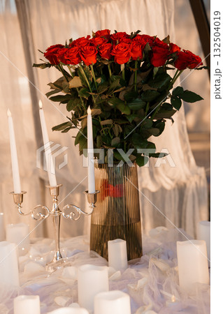 Romantic Red Roses Bouquet with Candles: Luxurious Valentine's Day Still Life, Dark Mood, Silver Accents, and Soft Lighting. Romantic Red Roses Bouquet with Candles: Luxurious Valentine's Day Still Life, Dark Mood, Silver Accents, and Soft Lighting. 132504019