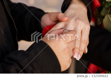 Romantic Engagement Proposal with Diamond Ring, Red Roses, Couple's Hands, Sunset Light, Love, Celebration, and Intimate Moment Photography. Romantic Engagement Proposal with Diamond Ring, Red Roses, Couple's Hands, Sunset Light, Love, Celebration, and Intimate Moment Photography. 132504022