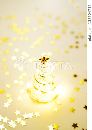 ガラスのクリスマスツリーとキラキラ輝くゴールドスター ガラスのクリスマスツリーとキラキラ輝くゴールドスター 132504752