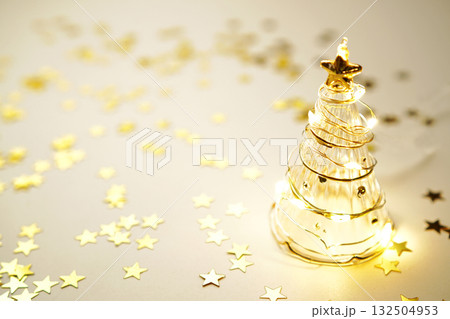 ガラスのクリスマスツリーとキラキラ輝くゴールドスター ガラスのクリスマスツリーとキラキラ輝くゴールドスター 132504953
