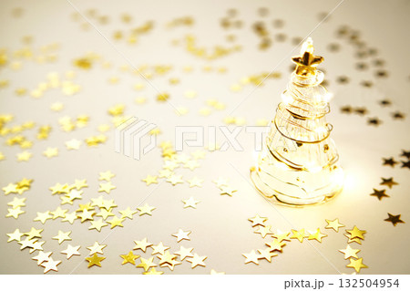 ガラスのクリスマスツリーとキラキラ輝くゴールドスター ガラスのクリスマスツリーとキラキラ輝くゴールドスター 132504954