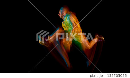 Basketball player in yellow uniform jumping forward with colorful light motion trail 132505026