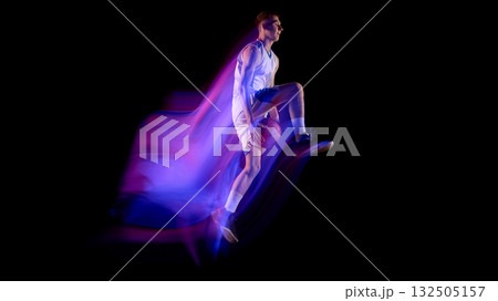 Basketball player in midair holding ball with vivid neon light trail on dark background 132505157
