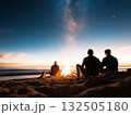 Three people sitting around a campfire 132505180