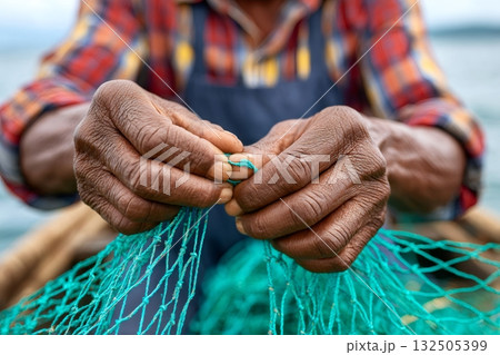 Fisherman repairing fishing net with his hands Fisherman repairing fishing net with his hands 132505399