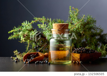 Juniper berry essential oil and branches with berries. Juniper berry essential oil and branches with berries. 132506505
