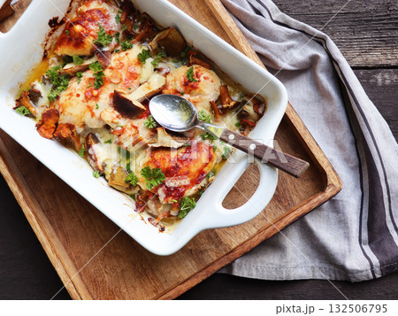 Roasted mushrooms, chicken and cheese gratin in pan, on wooden background Roasted mushrooms, chicken and cheese gratin in pan, on wooden background 132506795