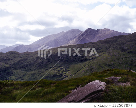 Breathtaking panorama. Emerald hills stretch towards distant peaks. Nature's beauty unveiled. 132507877