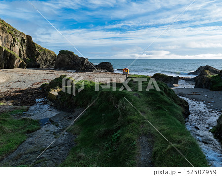 A picture of Sheep Cove in Ireland, looking out over the coast. You can see rocks, a sandy beach, safety equipment and green grass. A picture of Sheep Cove in Ireland, looking out over the coast. You can see rocks, a sandy beach, safety equipment and green grass. 132507959