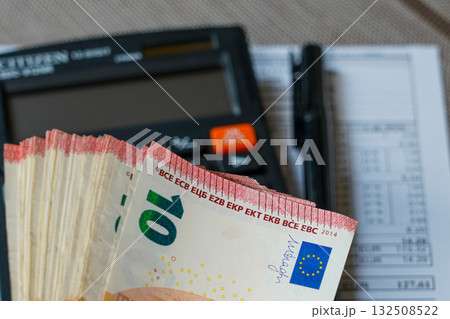 Stack of euro banknotes with calculator and pen symbolizing accounting, finance, and money management Stack of euro banknotes with calculator and pen symbolizing accounting, finance, and money management 132508522