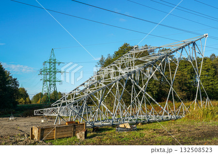 New steel power transmission tower under construction near green pylons and high-voltage lines New steel power transmission tower under construction near green pylons and high-voltage lines 132508523