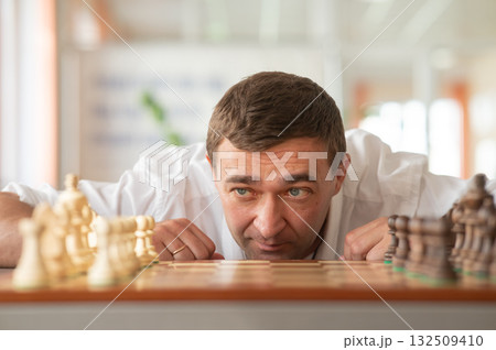 Middle aged Caucasian man playing chess.  132509410