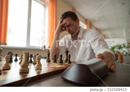 A man switches a chess clock.  132509413