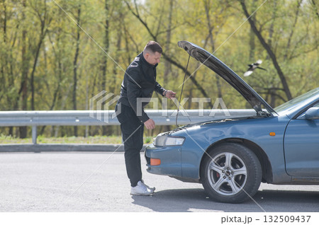 Caucasian man checking engine oil level in his car. Caucasian man checking engine oil level in his car. 132509437