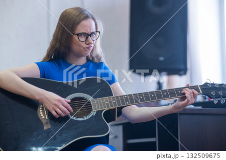 Young woman playing guitar in recording studio. Young woman playing guitar in recording studio. 132509675