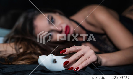 Woman in lace lingerie holding white clitoral vacuum stimulator.  132509727