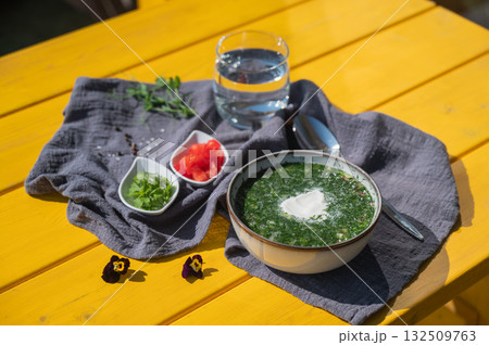 Traditional Russian lunch in a cafe. Top view of okroshka on a table in a summer cafe. Traditional Russian lunch in a cafe. Top view of okroshka on a table in a summer cafe. 132509763