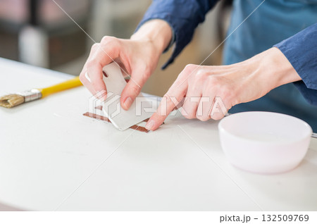 Leatherworker measuring and cutting leather in workshop. Leatherworker measuring and cutting leather in workshop. 132509769