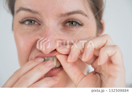 A woman uses chewing tobacco. A woman uses chewing tobacco. 132509884