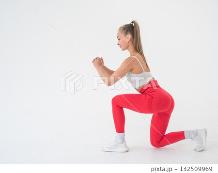 Young woman doing lunges on white cyclorama background. Vertical video. Young woman doing lunges on white cyclorama background. Vertical video. 132509969