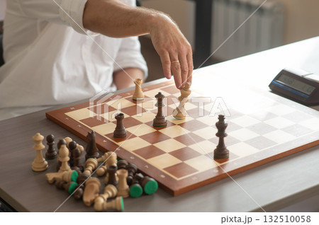 Close up of hands of middle aged caucasian man playing chess. Close up of hands of middle aged caucasian man playing chess. 132510058