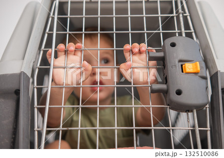 A small child in a closed cage. A small child in a closed cage. 132510086
