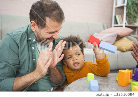 Multiracial family plays with colorful building blocks 132510094