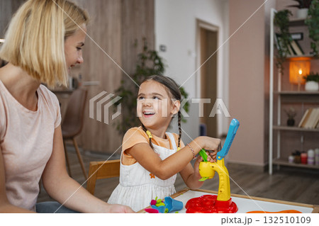 Mother and daughter enjoying creative playtime modeling plasticine Mother and daughter enjoying creative playtime modeling plasticine 132510109