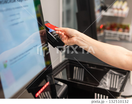 Woman paying with credit card at self-checkout. Woman paying with credit card at self-checkout. 132510132
