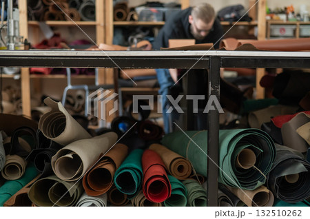 Caucasian bearded man working as a tanner in a workshop. Caucasian bearded man working as a tanner in a workshop. 132510262