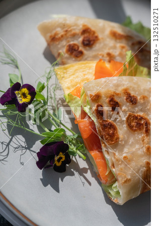 A flatbread stuffed with fish and cheese served in a cafe. Quesadilla. 132510271