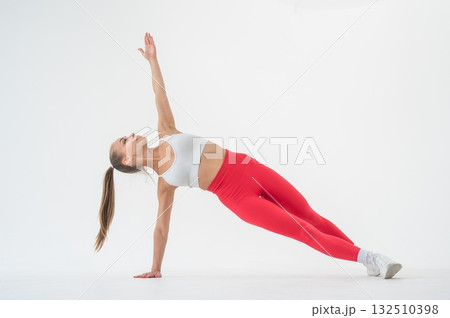 Young woman doing side plank on white background. Young woman doing side plank on white background. 132510398