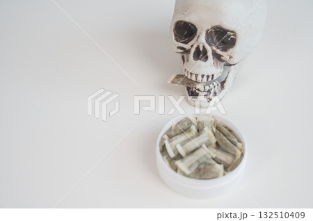 Skull Chewing Tobacco on a White Table. 132510409