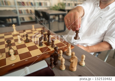 Close up of hands of middle aged caucasian man playing chess. Close up of hands of middle aged caucasian man playing chess. 132510482