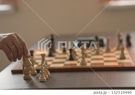 Close up of hands of middle aged caucasian man playing chess. Close up of hands of middle aged caucasian man playing chess. 132510490