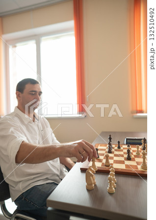Middle aged Caucasian man playing chess.  132510492