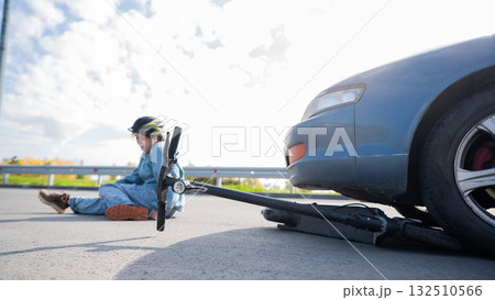 A Caucasian woman on a scooter after being hit by a car. 132510566