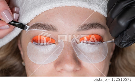 The process of professional lamination and dyeing of eyelashes and eyebrows in the salon. Four-handed procedure.  132510575