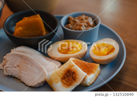 煮卵と鶏ハム、かぼちゃの煮物や納豆を添えた和風の朝食プレート 132510840