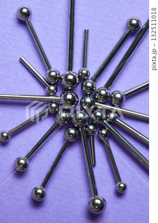 Piercing earrings close-up. On a Violet background. Piercing earrings close-up. On a Violet background. 132511018