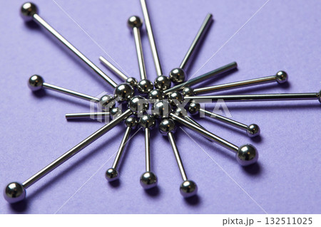 Piercing earrings close-up. On a Violet background. 132511025