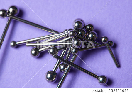 Piercing earrings close-up. On a Violet background. Piercing earrings close-up. On a Violet background. 132511035