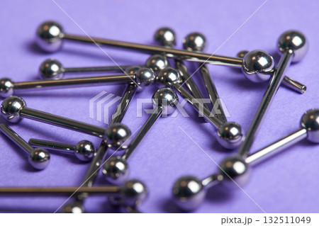 Piercing earrings close-up. On a Violet background. Piercing earrings close-up. On a Violet background. 132511049