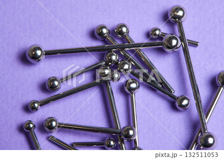 Piercing earrings close-up. On a Violet background. 132511053