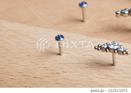 Beautiful piercing jewelry on wooden display. Macro shot. Selective focus. 132511071