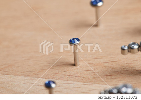 Beautiful piercing jewelry on wooden display. Macro shot. Selective focus. Beautiful piercing jewelry on wooden display. Macro shot. Selective focus. 132511072