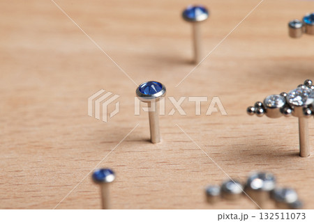 Beautiful piercing jewelry on wooden display. Macro shot. Selective focus. 132511073
