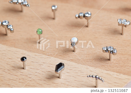 Beautiful piercing jewelry on wooden display. Macro shot. Selective focus. 132511087